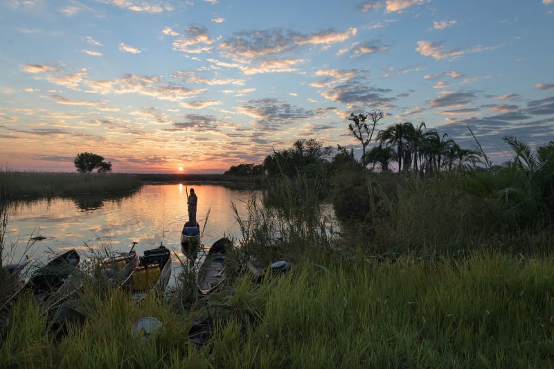 Wetland of international importance in Angola with lush vegetation and calm waters at sunset.