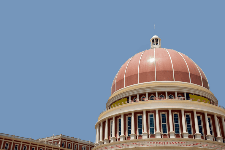 Iconic dome of Angola's government building against clear blue sky.