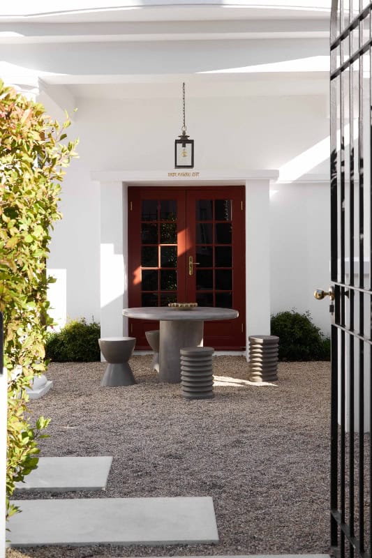 Elegant hotel entrance with wooden door and outdoor seating area in Cape Town.