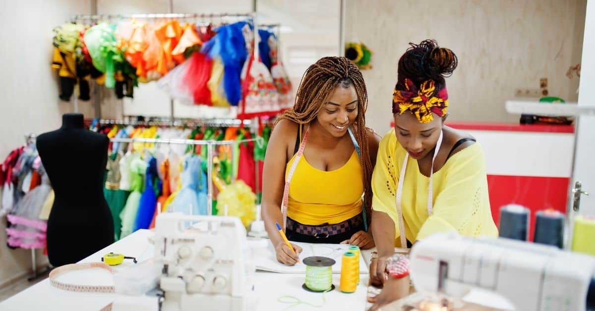 Women sewing colorful fabrics in an African small business setting.