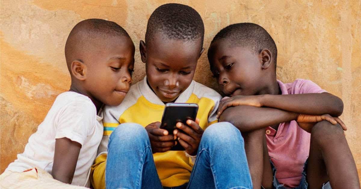 African children engaging with mobile technology for education.