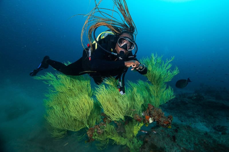 Diving instructor Mama Sli explores vibrant underwater coral reefs in Sodwana Bay, showcasing Africa.
