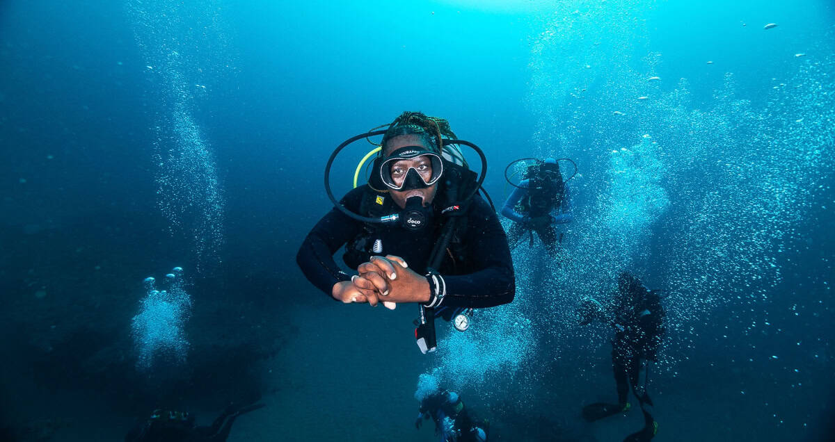 Dive instructor Mama Sli underwater in Sodwana Bay, Africa, showcasing ocean access for African stor.