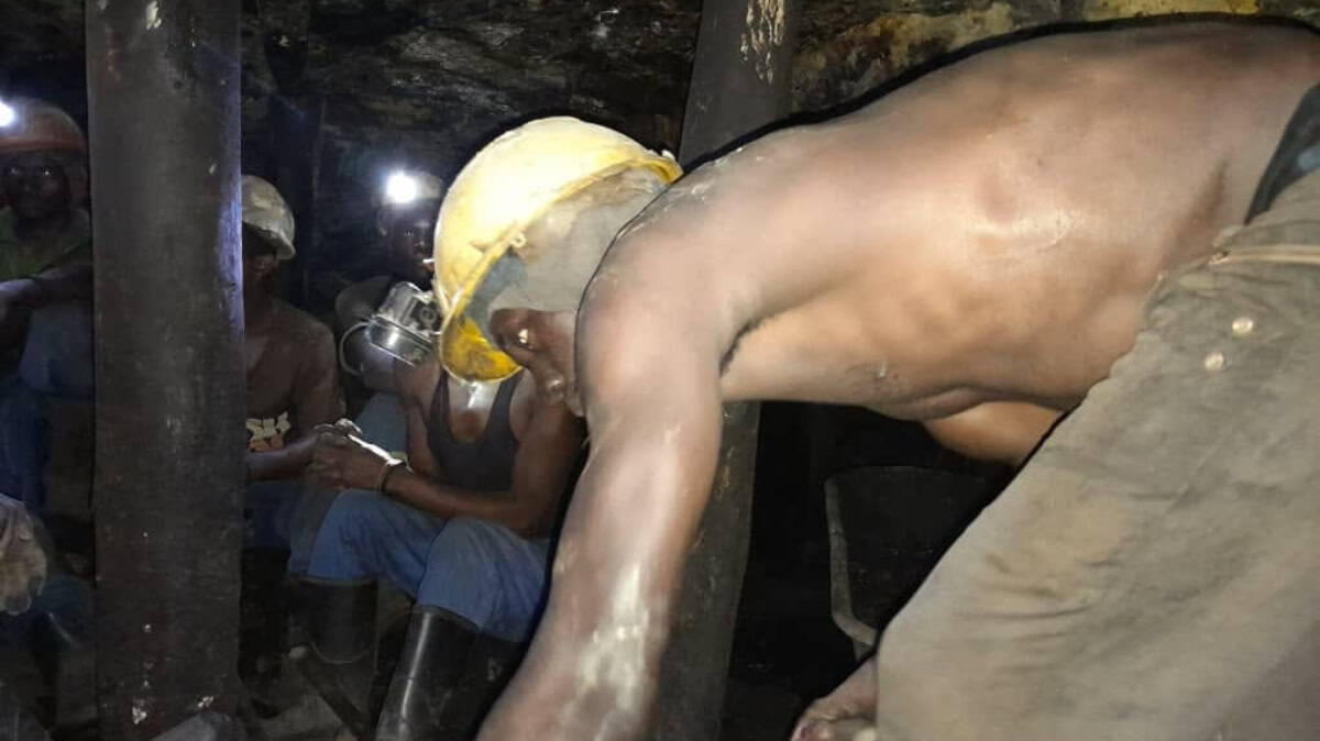 Mining workers in safety helmets working in an underground mining environment.