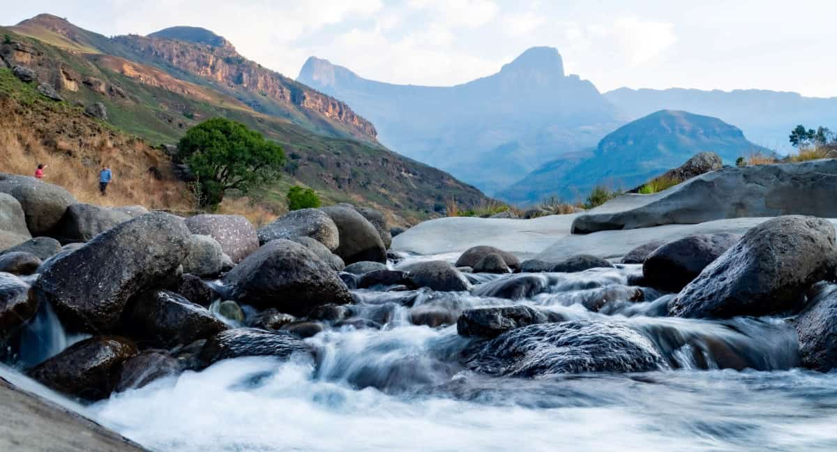 Water source protection in a scenic mountain landscape with flowing river and rocky terrain.