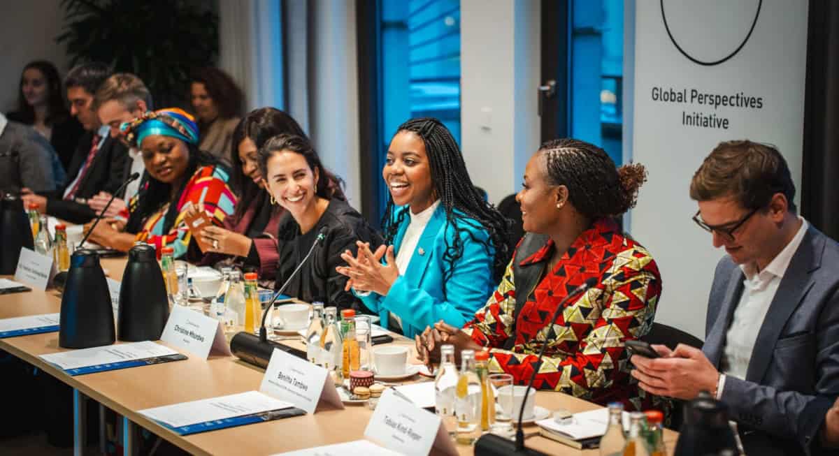 Diverse media professionals discuss challenges at a roundtable.
