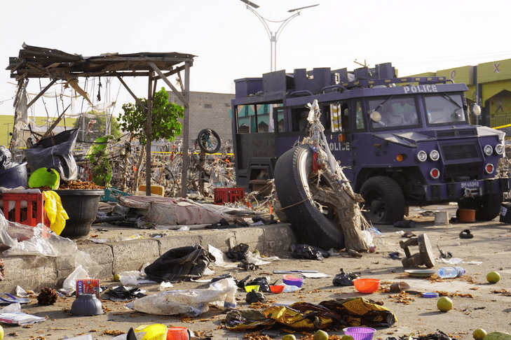 Damaged police vehicle amidst debris after Maiduguri bombings in Nigeria.