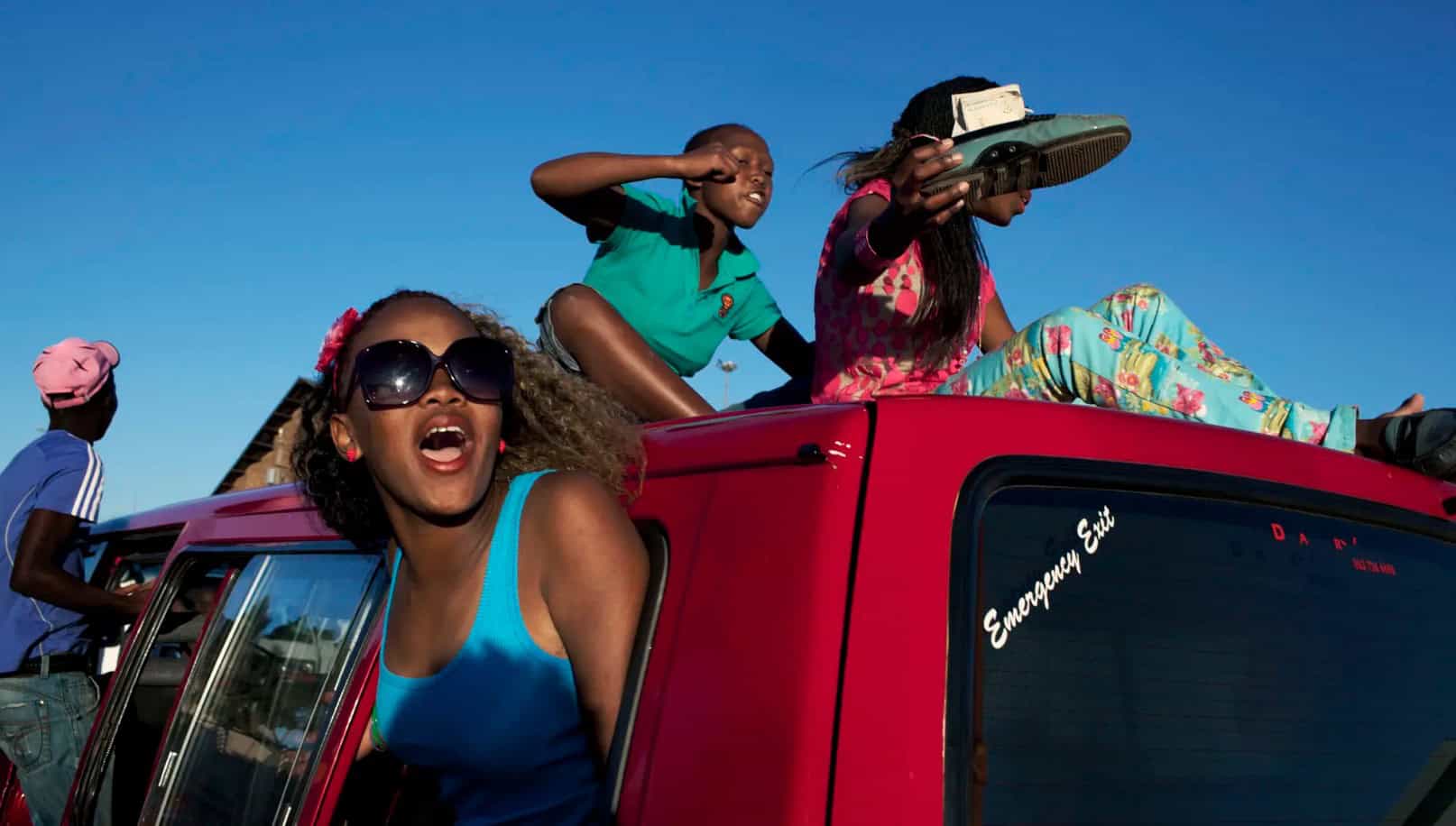 Young Africans showcasing Skhothane culture on a vehicle in Africa.