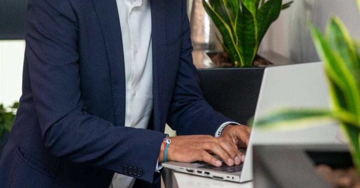 Business professional working on a laptop in an office setting.