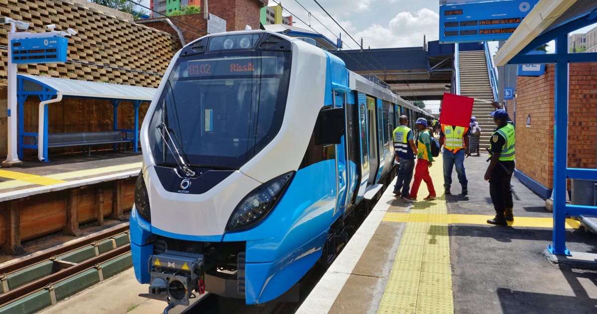 Modern South African train at urban station for rail development.
