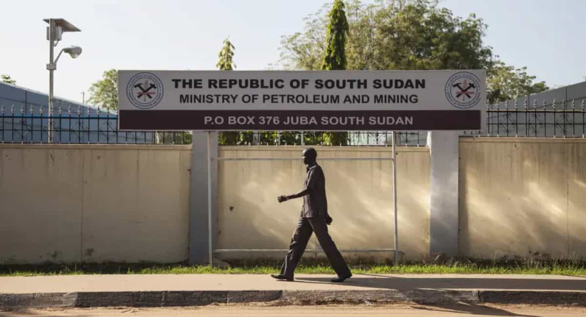 Man walking past South Sudan Ministry of Petroleum sign in Juba.
