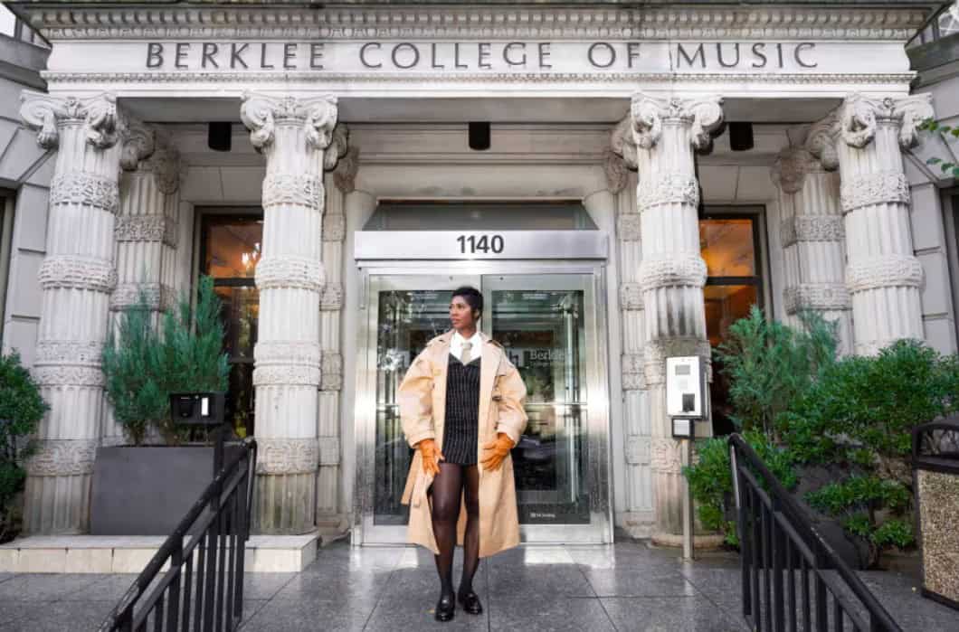 Berklee College of Music building with a woman standing outside, symbolizing music education and men.
