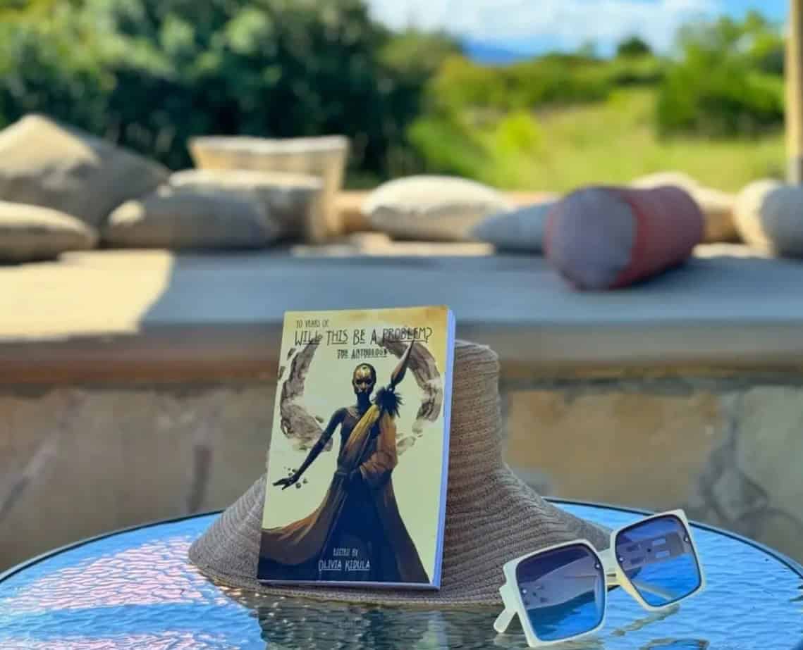 Sun hat and sunglasses with a travel card on a table outdoors.