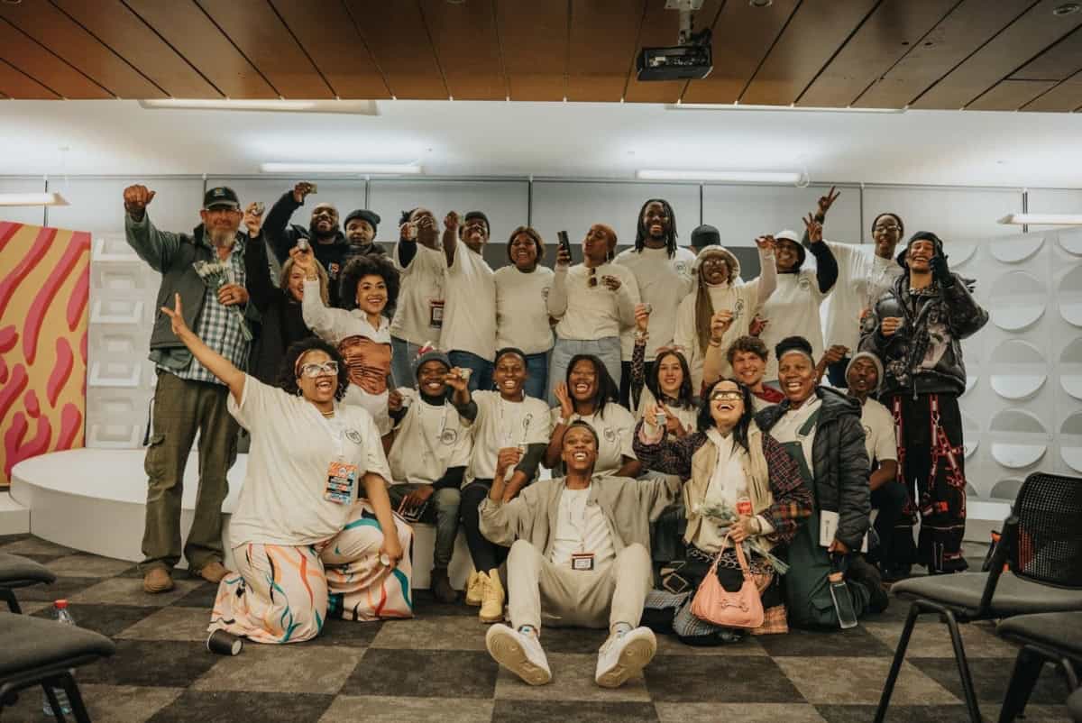 Diverse attendees at Africa Rising Music Conference pose joyfully in a modern conference room.