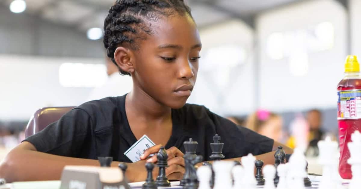 Young South African girl focused on a chess game during a tournament.