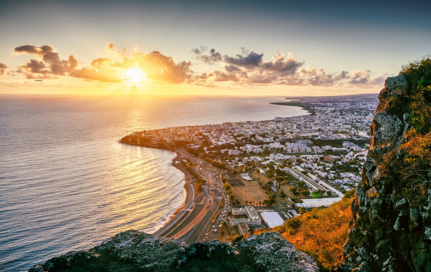 Sunset illuminating the Cape Town coast with vibrant colors and scenic views of the city and ocean.