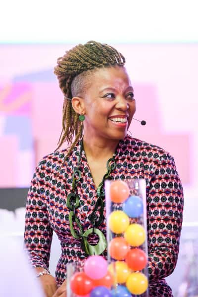 Empowered African woman speaking at a conference, symbolizing creativity and innovation in Africa’s.