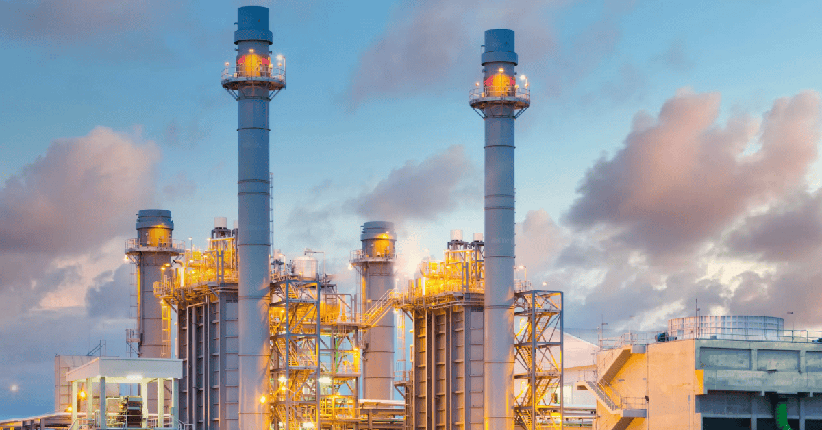 South African power plant with industrial infrastructure and smokestacks under a cloudy sky.