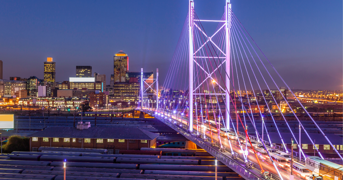 Brightly lit Lisbon bridge connecting city districts at sunset.