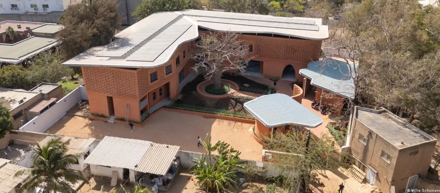Aerial view of a contemporary African brick house featuring a spacious courtyard and lush landscapin.