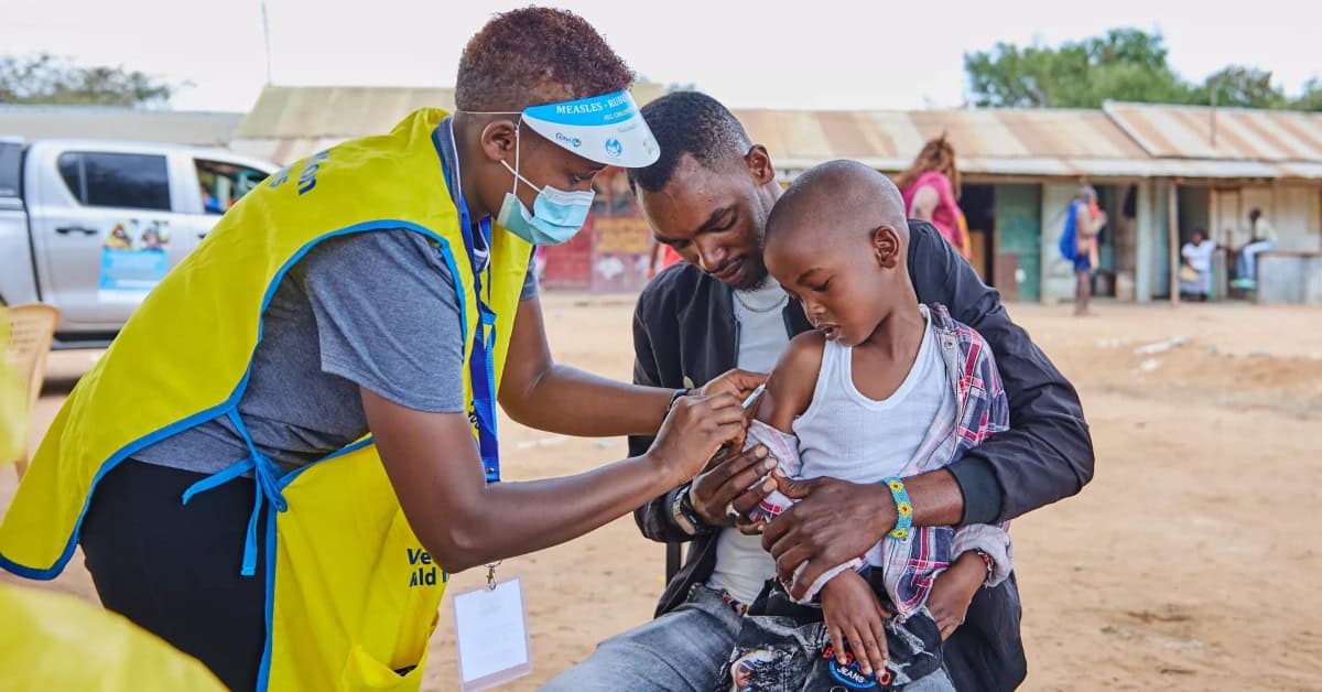 Child receiving vaccination from health worker in Africa.