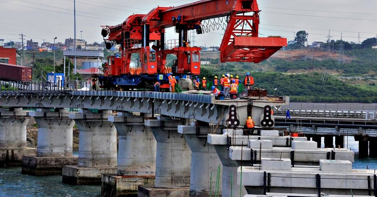 Bridge construction with heavy machinery and workers in progress.