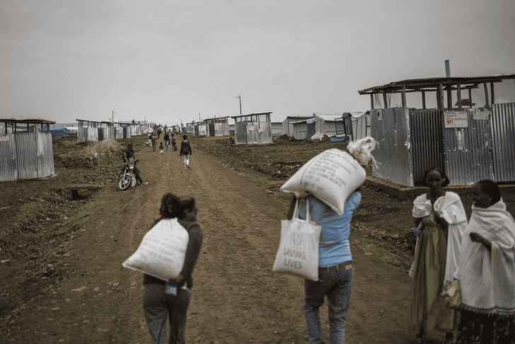 Refugees walking through a camp with makeshift shelters in Tigray, Ethiopia.