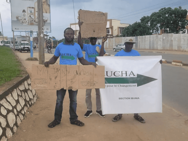 Protesters hold signs and banners advocating for change during a peaceful demonstration in DR Congo.