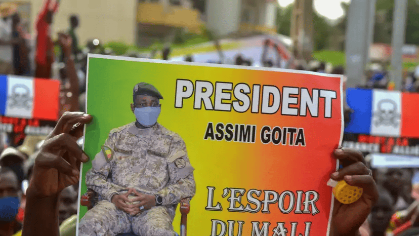 Mali President Assimi Goita during a political rally, wearing military uniform and face mask.