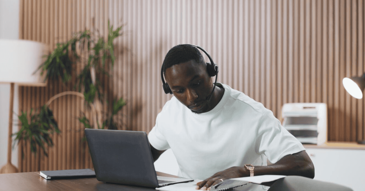 Young man working on a laptop with headphones, representing tech employment challenges in South Afri.