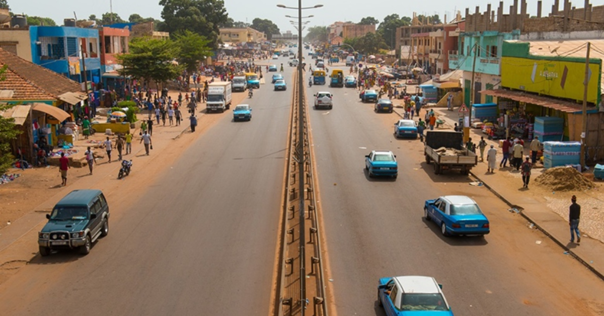 Busy African city street with vehicles and pedestrians, showcasing economic activity.