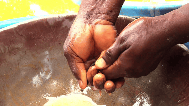 Gladys Akitsa, an artisanal gold miner, mixes mercury with gold-bearing concentrate at the Bushiangala mining site in Ikolomani, Kakamega County, Kenya. Credit: Chemtai Kirui/IPS