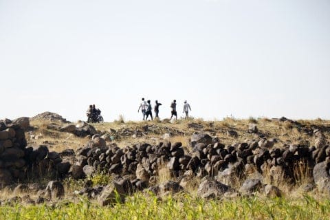Hikers trekking across rocky landscape in Ethiopia, showcasing adventure and natural beauty.
