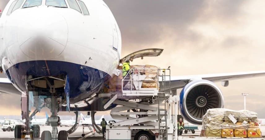 Airplane being loaded with cargo at airport terminal.