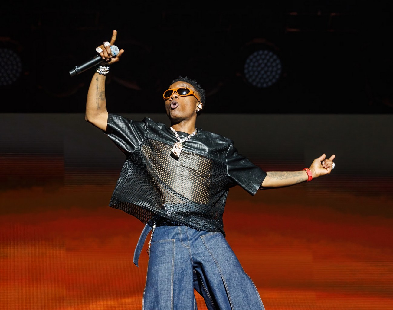 African singer performing live with dynamic stage presence and colorful lighting.