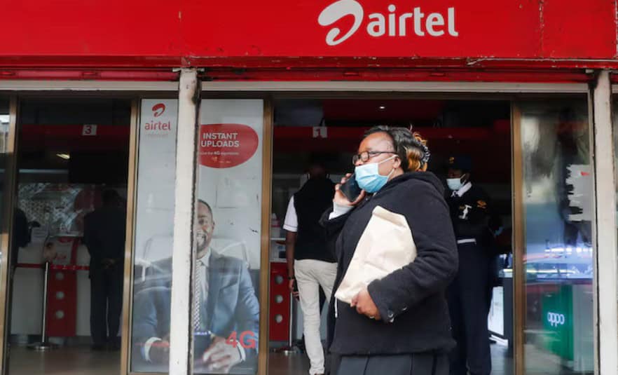 Woman wearing face mask outside Airtel store in Africa.