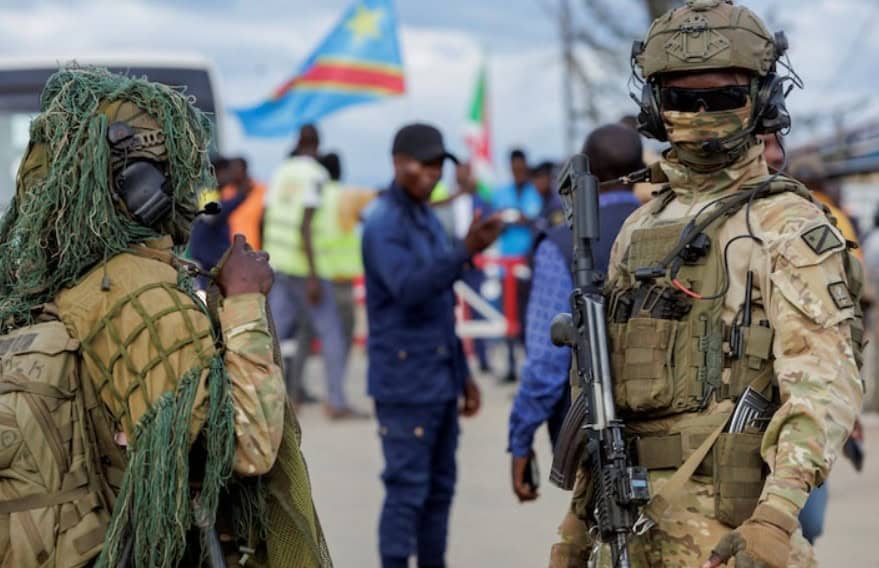 Security personnel in tactical uniforms and gear at a public gathering in Africa.