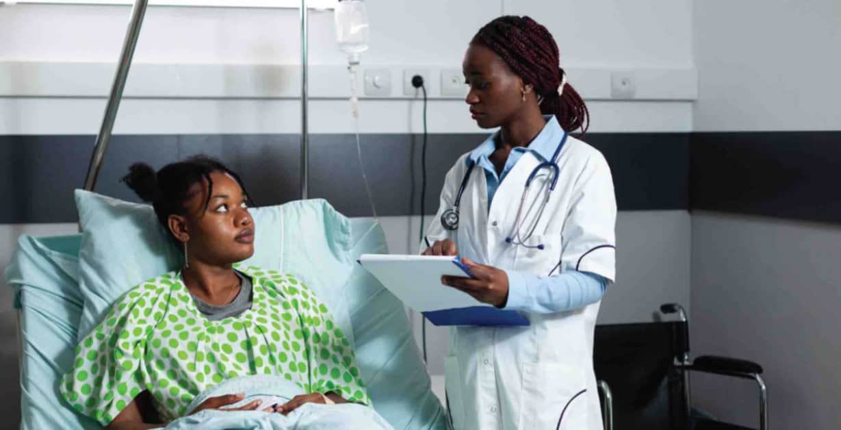 Medical consultation with a healthcare professional and a young patient in a hospital setting.