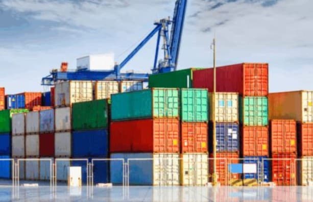 Shipping containers at an African port with a crane for cargo handling.