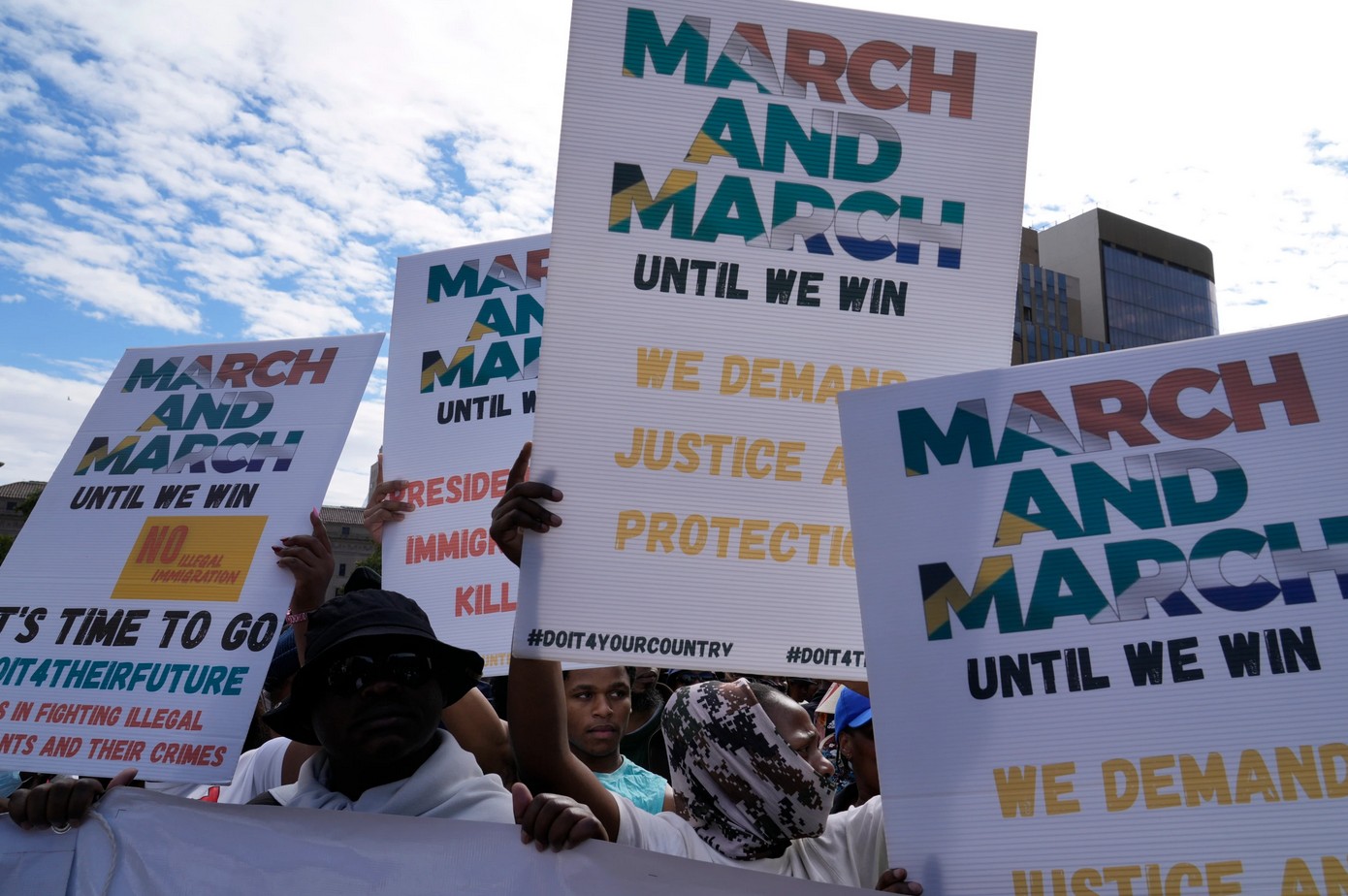 Protesters hold signs demanding justice, equality, and action during a March and March rally.