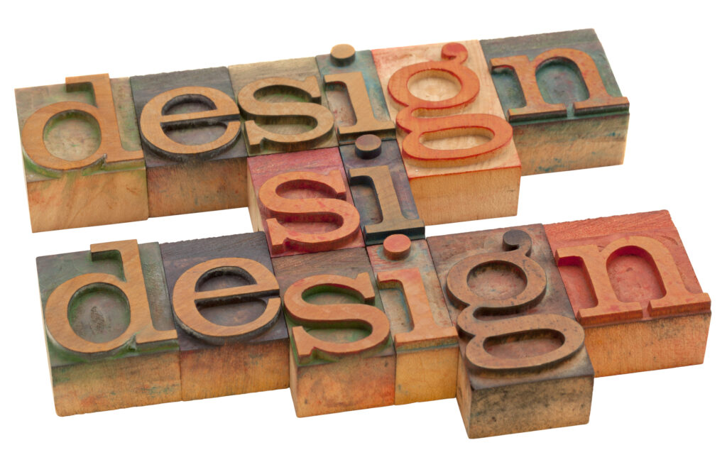 Two rows of vintage wooden letterpress blocks arranged to spell "design" — with the overlapping middle letters reading "si si si" — in warm earth tones, suggesting the craft and iterative nature of the design process.