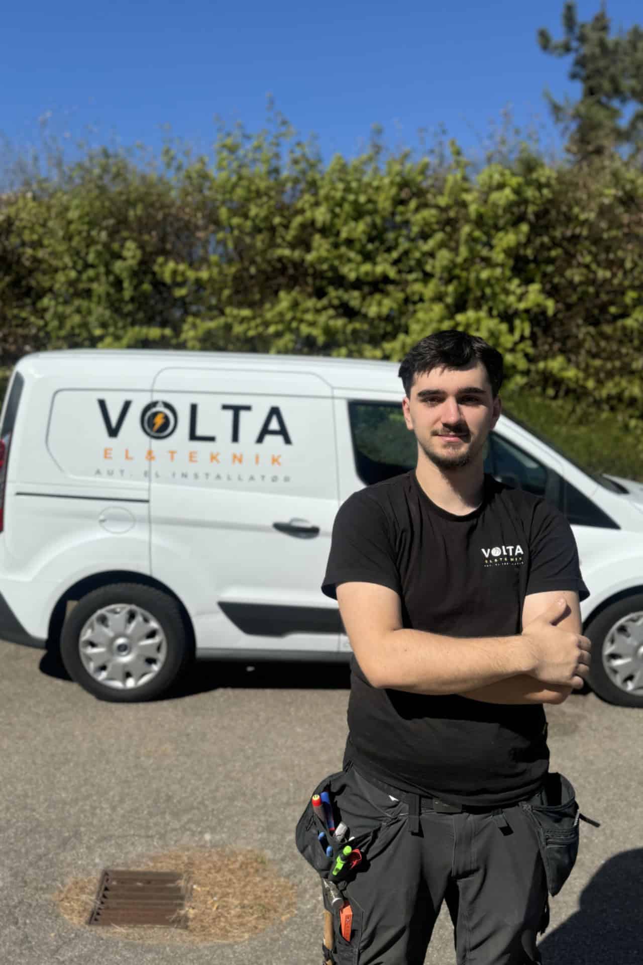 Elektriker fra Volta El & Teknik stående foran en hvid firmabil.