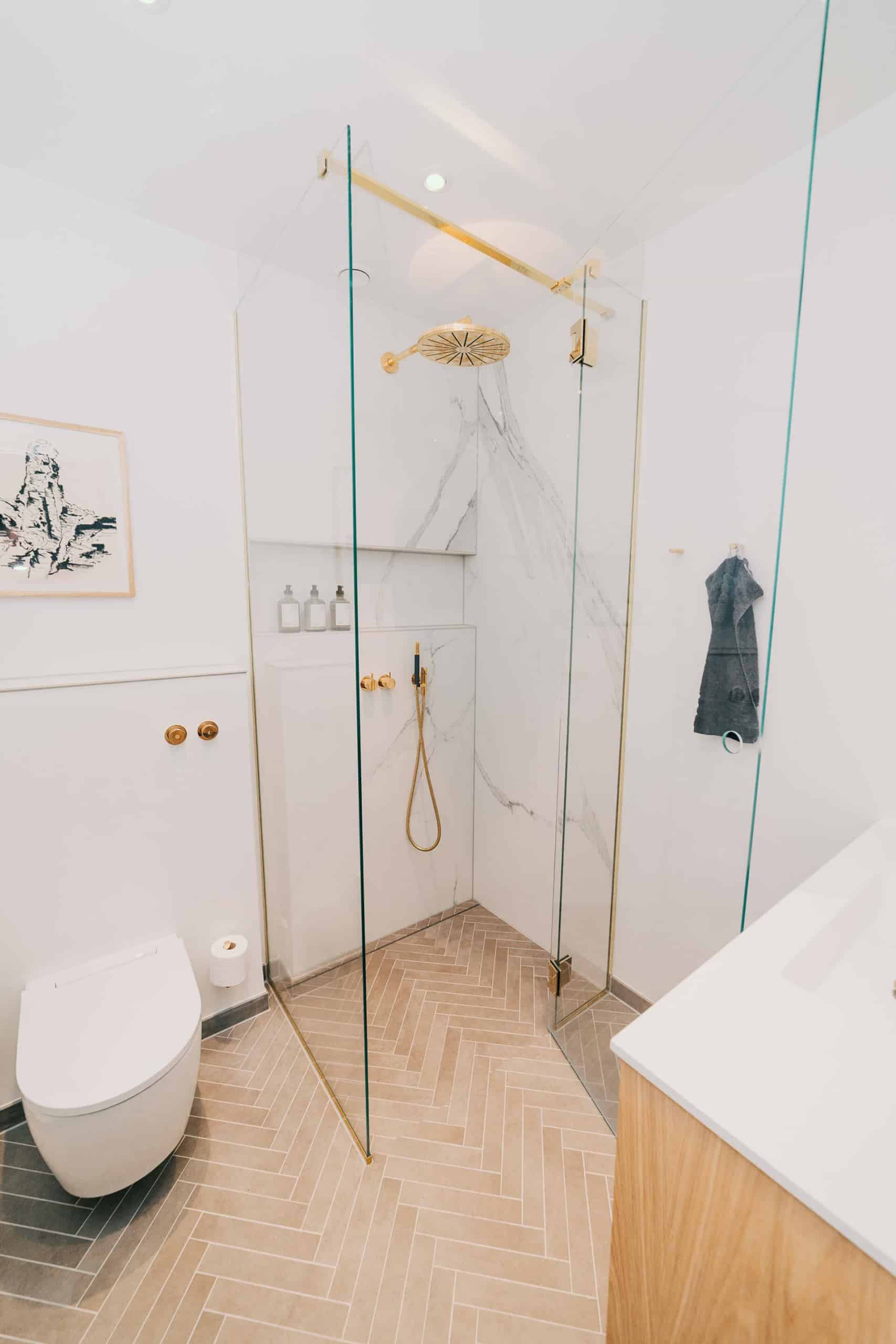 hvidt badeværelse med detaljer i guld og træ