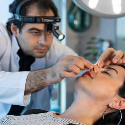 Chirurgien esthétique du Liv Hospital en Turquie examinant le nez d’une patiente avant une rhinoplastie