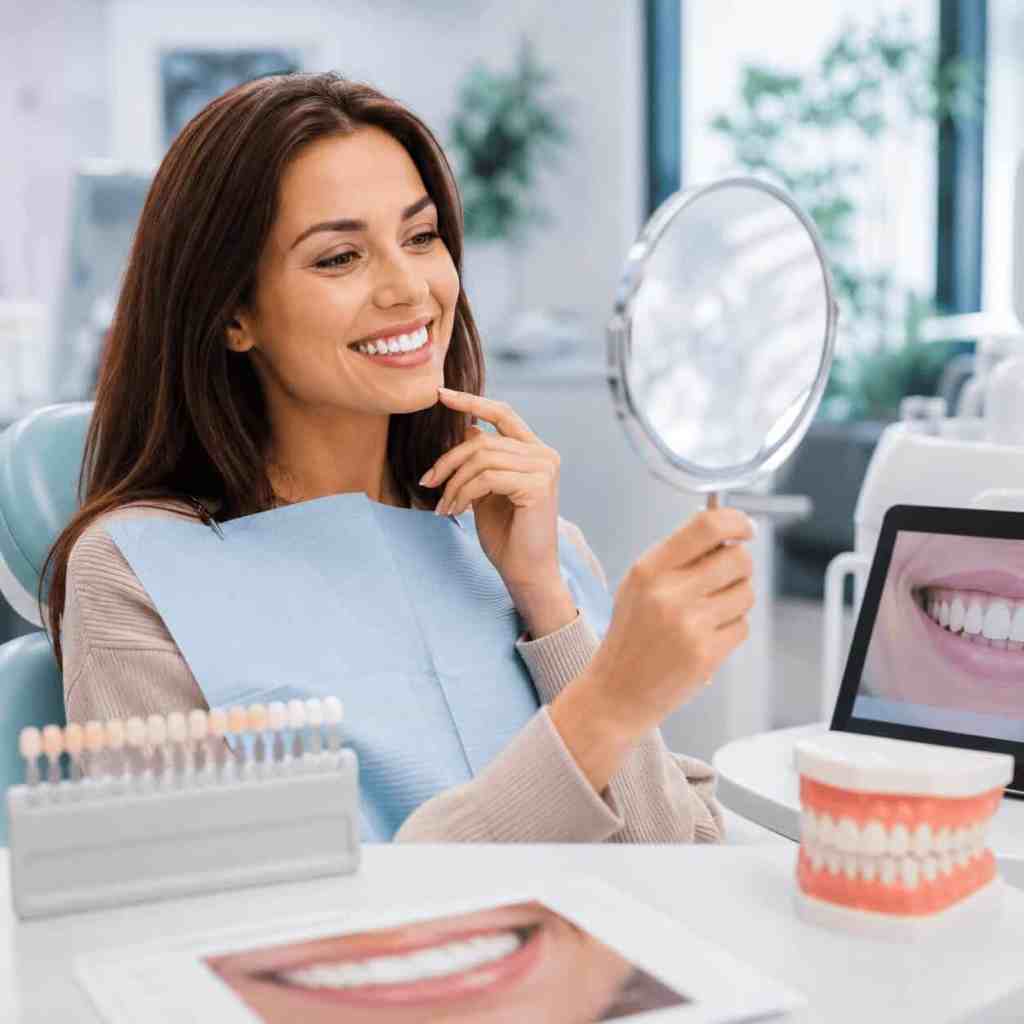Patiente observant son sourire dans un miroir pour évaluer le résultat avec huit facettes dentaires