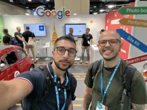 Due uomini sorridenti che si scattano un selfie allo stand Google Site Kit durante una conferenza sullo sviluppo web.