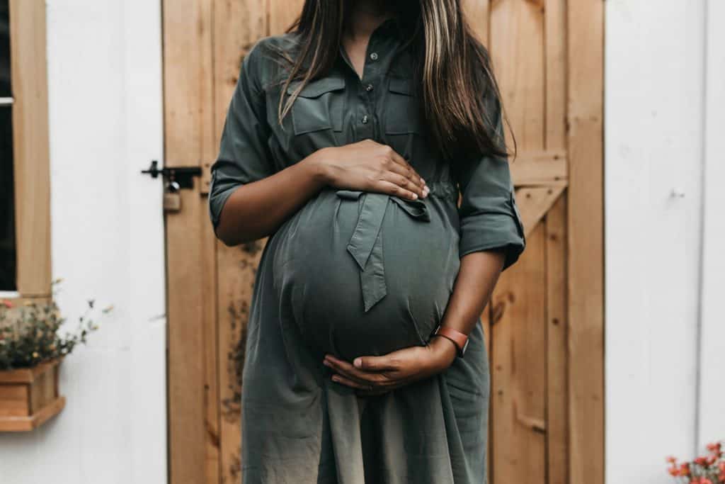 Pregnant woman working on a laptop at home — exploring ways to make money while pregnant