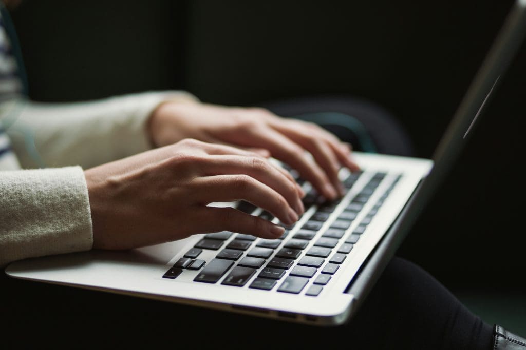 Close-up of a person filling out a form with a pen, representing the process of completing Form 2553​