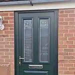 Dark green uPVC front door with glass panels, letterbox, and brass handle installed by CP Glazing Ltd.