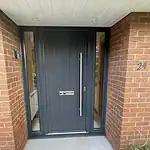 Modern black front door with glass side panels, durable security handle, and letterbox. Perfect for contemporary home entrances.
